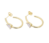 Gold hoop earrings with clear stones on a light gray background